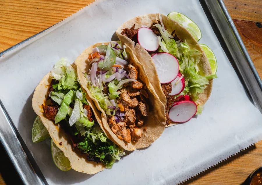 A tray of freshly built tacos on the counter