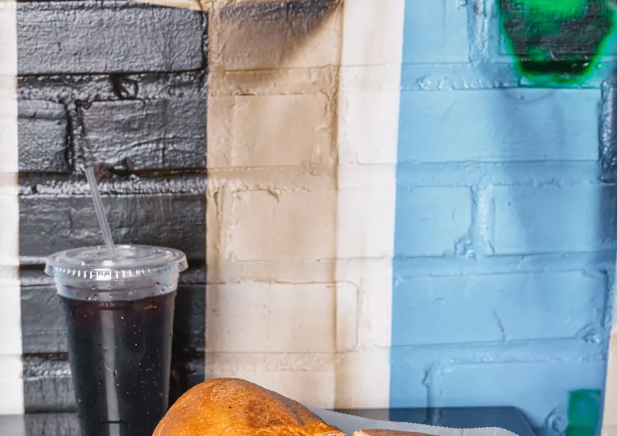 A Mexican torta cut in half on paper